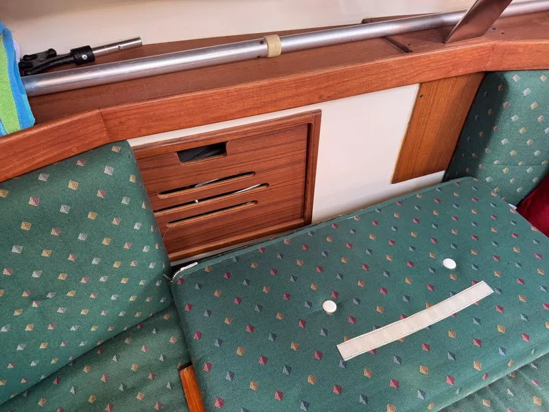 Slide: The Image of Interior of a 1997 Tartan 3500 sailboat with patterned green upholstery and wooden accents. - 10