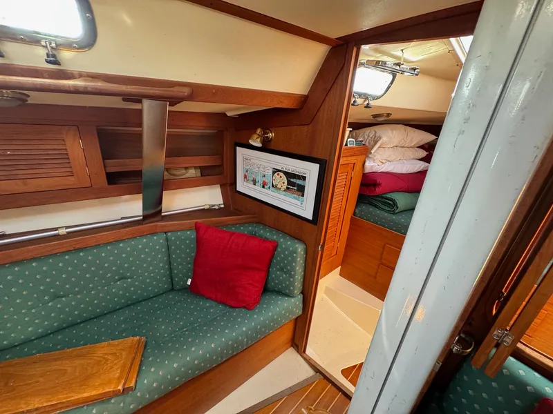 Slide: The Image of Cozy interior of 1997 Tartan 3500 sailboat with green seating and wooden accents. - 11