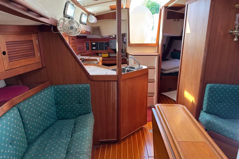 Slide: The Image of Interior of a 1997 Tartan 3500 sailboat with wood finish and green upholstery. - 12