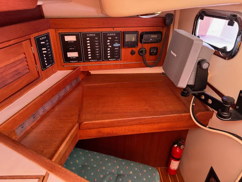 Slide: The Image of Navigation station on a 1997 Tartan 3500 sailboat with control panels and equipment. - 19