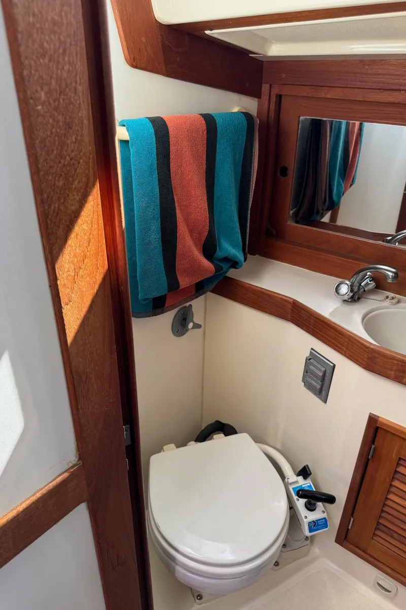 Slide: The Image of Compact bathroom in a 1997 Tartan 3500 sailboat with wooden accents and colorful towel. - 20