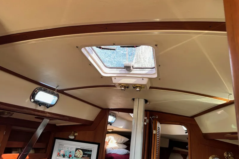 Slide: The Image of Interior of a 1997 Tartan 3500 sailboat, featuring a skylight and wooden trim. - 24