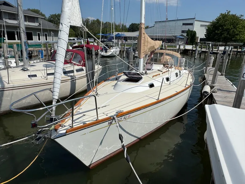 Slide: The Image of 1997 Tartan 3500 sailboat docked at marina, featuring white hull and wooden accents. - 3