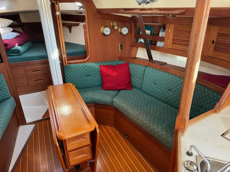 Slide: The Image of Cozy interior of a 1997 Tartan 3500 sailboat with green upholstery and wooden finishes. - 6