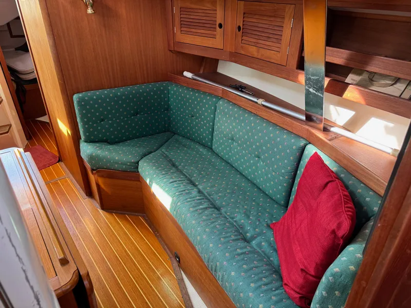 Slide: The Image of Cozy interior of a 1997 Tartan 3500 sailboat with green upholstery and wooden accents. - 8