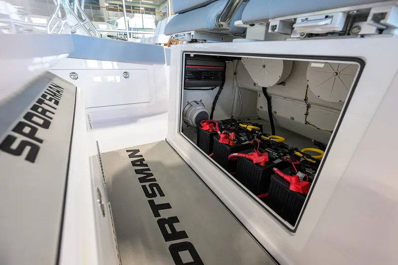 Slide: The Image of 2026 Sportsman Heritage 321 Center Console boat battery compartment with visible wiring. - 22