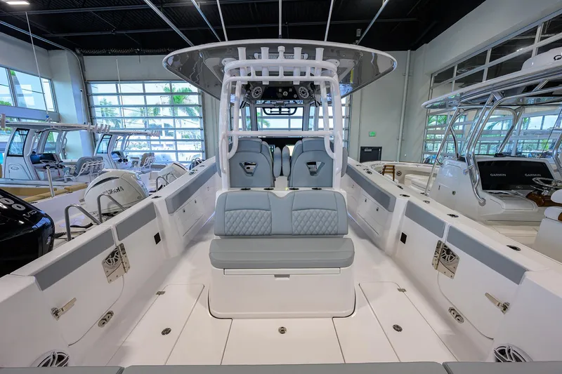 Slide: The Image of 2026 Sportsman Heritage 321 Center Console boat interior in showroom, featuring modern seating and controls. - 27