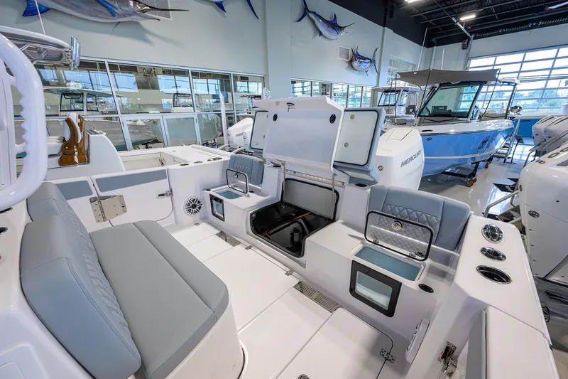 Slide: The Image of 2026 Sportsman Heritage 321 Center Console boat interior in showroom, featuring seating and storage compartments. - 31