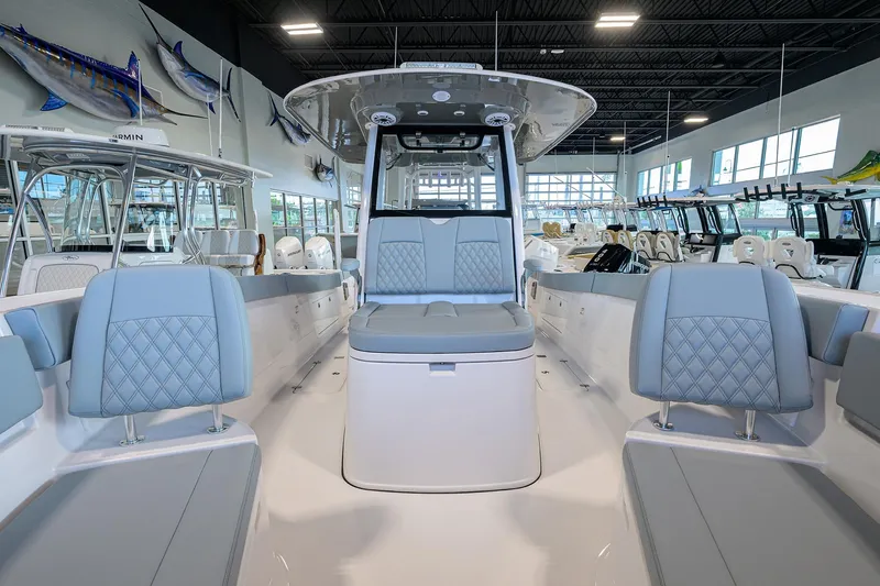 Slide: The Image of 2026 Sportsman Heritage 321 Center Console boat interior with blue seating in showroom. - 6