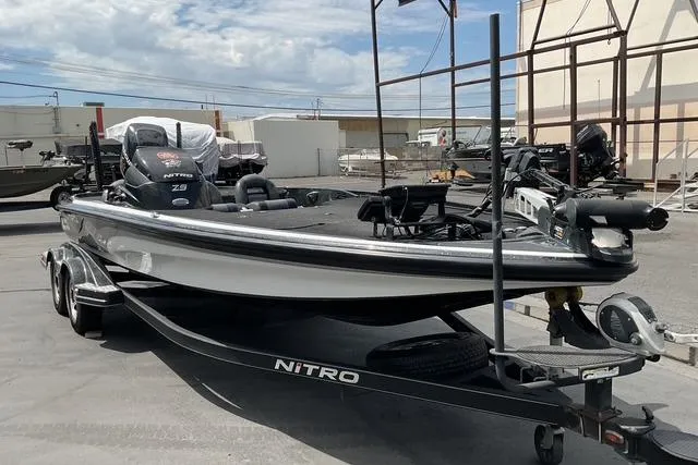 Slide: The Image of 2015 Nitro Z-9 fishing boat on trailer, parked outdoors under cloudy sky. - 2