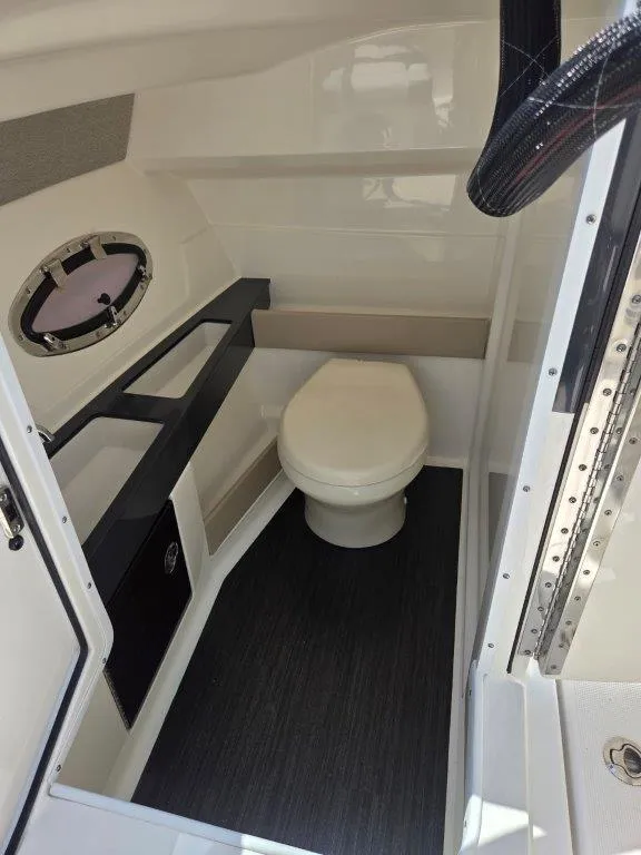 Slide: The Image of 2016 Formula 290 Bowrider interior bathroom with toilet and porthole window. - 3