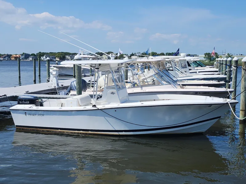 Slide: The Image of 2002 Regulator 23 Classic boat docked at marina, clear sky, calm water. - 0