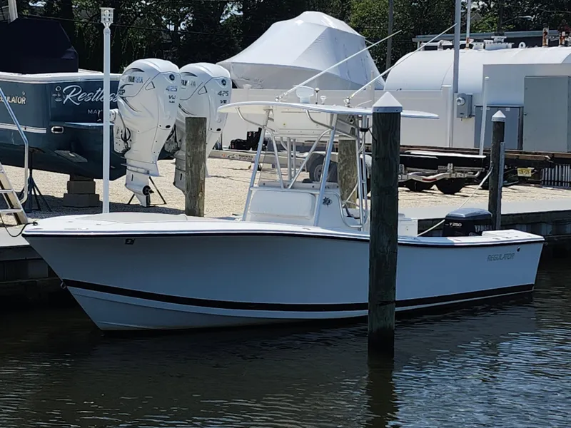 Slide: The Image of 2002 Regulator 23 Classic boat docked at marina with Yamaha outboard engine. - 1