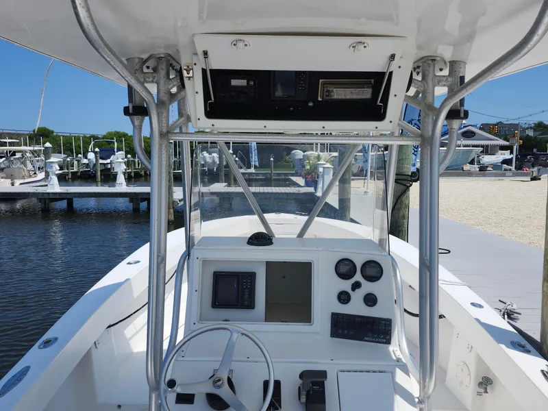 Slide: The Image of 2002 Regulator 23 Classic boat dashboard with steering wheel and gauges at marina. - 13