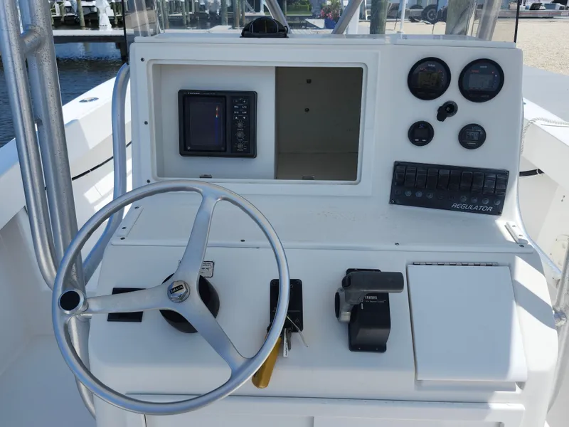 Slide: The Image of 2002 Regulator 23 Classic boat dashboard with steering wheel, gauges, and controls. - 14