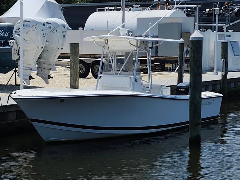 Slide: The Image of 2002 Regulator 23 Classic boat docked at marina with twin Yamaha engines. - 3