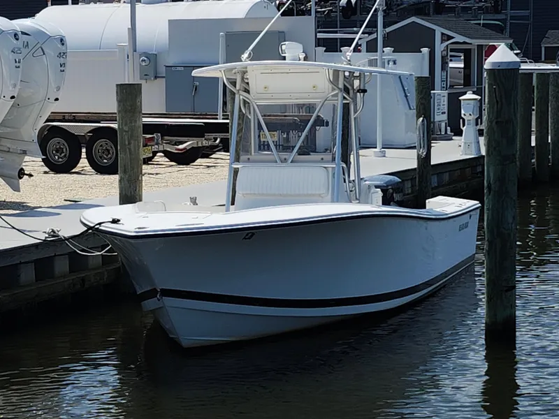 Slide: The Image of 2002 Regulator 23 Classic boat docked at marina, featuring sleek white design. - 6