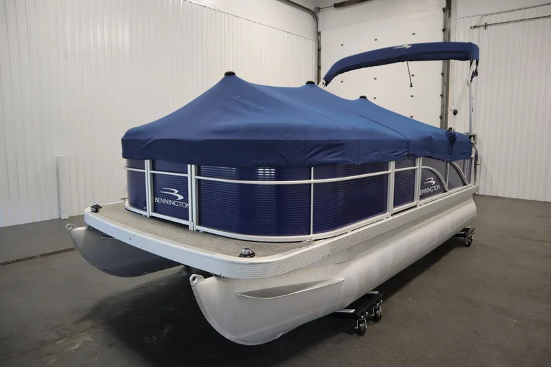 Slide: The Image of 2020 Bennington 16 SL pontoon boat with blue cover in indoor storage. - 40