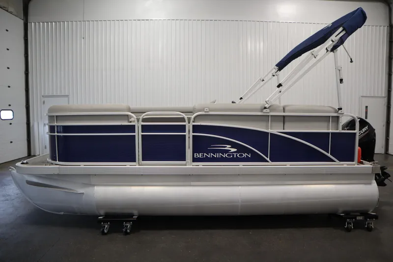 Slide: The Image of 2020 Bennington 16 SL pontoon boat with blue and silver design in a garage. - 8