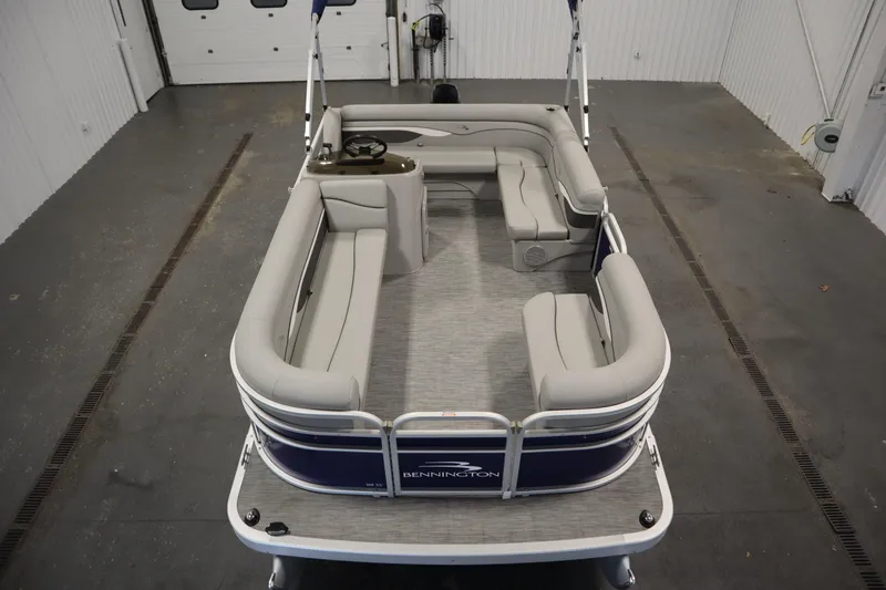 Slide: The Image of 2020 Bennington 16 SL pontoon boat with spacious seating in a garage setting. - 9