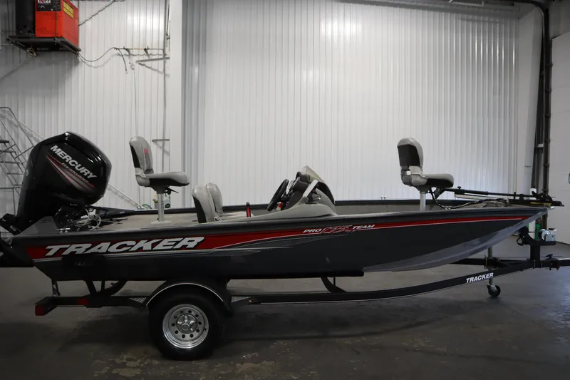 Slide: The Image of 2017 Tracker 20 CW Pontoon boat with Mercury engine in a garage setting. - 4
