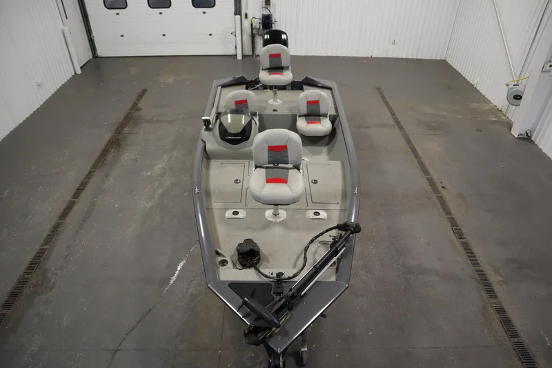 Slide: The Image of 2017 Tracker 20 CW Pontoon boat in a garage, featuring gray and red seating. - 9