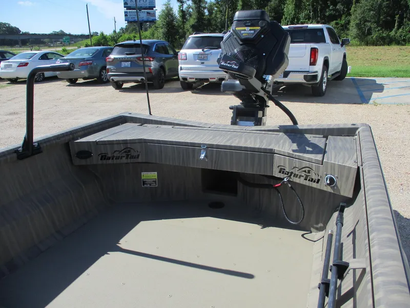 Slide: The Image of 2025 Gator Tail 1754 Extreme boat interior with motor, parked in a lot. - 11