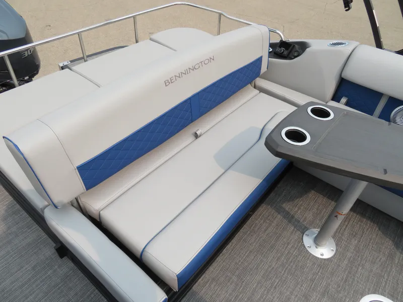 Slide: The Image of 2024 Bennington 25 LTSB boat interior with cushioned seating and table. - 12