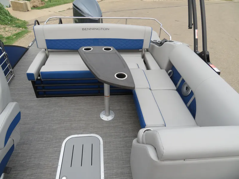 Slide: The Image of 2024 Bennington 25 LTSB pontoon boat interior with gray and blue seating and table. - 9
