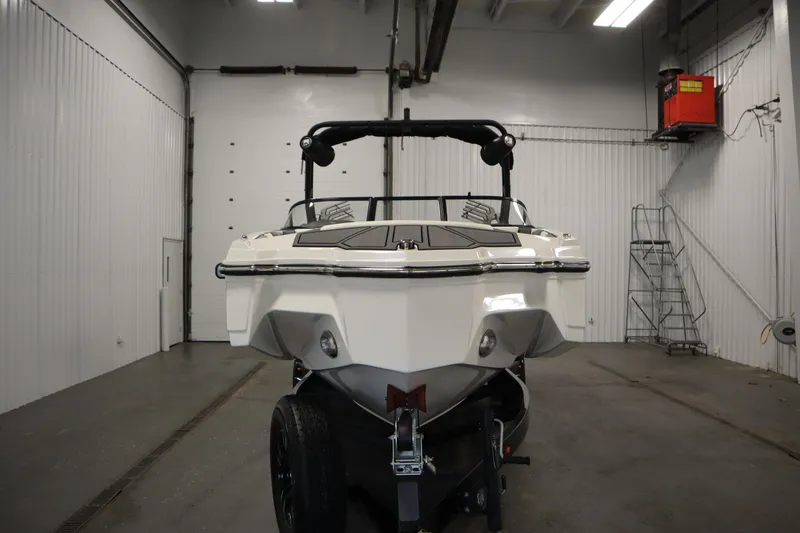 Slide: The Image of 2023 Heyday WT Surf boat in a garage, rear view. - 2