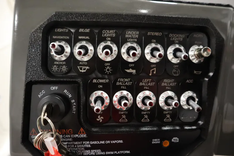 Slide: The Image of Control panel of 2023 Heyday WT Surf boat with various switches and key ignition. - 23