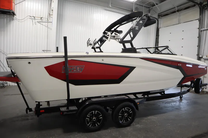 Slide: The Image of 2023 Heyday WT Surf boat in a garage, featuring a sleek red and white design. - 4