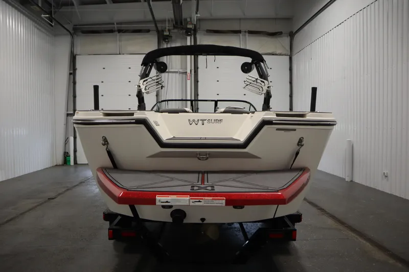 Slide: The Image of 2023 Heyday WT Surf boat in a garage, rear view showcasing sleek design. - 6
