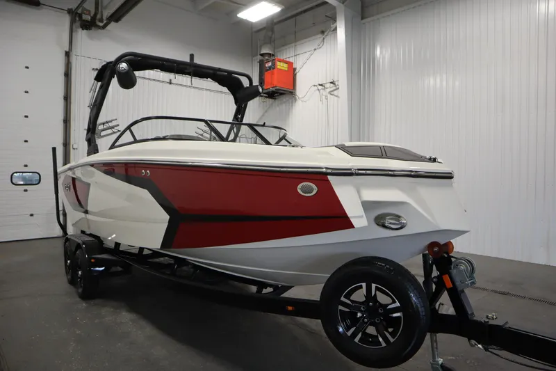 Slide: The Image of 2023 Heyday WT Surf boat with red and white design in a garage setting. - 3