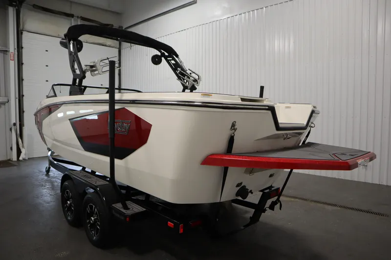 Slide: The Image of 2023 Heyday WT Surf boat in a garage, showcasing sleek design and trailer. - 7