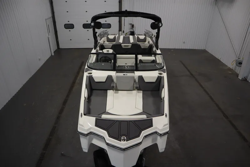 Slide: The Image of 2023 Heyday WT Surf boat in a garage, showcasing sleek design and spacious seating. - 9
