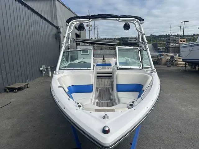 Slide: The Image of 2007 Nautique Super Air Nautique 210 boat with blue and white interior, docked outdoors. - 3
