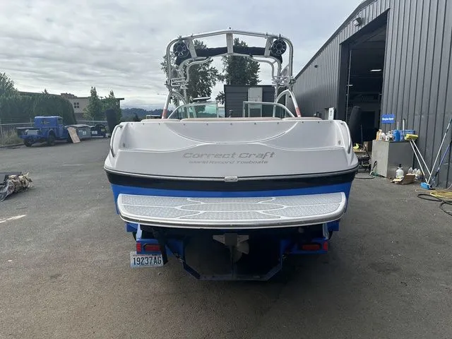Slide: The Image of 2007 Nautique Super Air Nautique 210 boat, rear view, parked outdoors near a warehouse. - 5