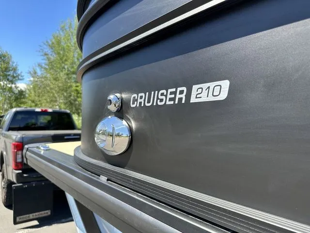 Slide: The Image of 2025 Harris Cruiser 210 CWDH boat detail with truck in background. - 11