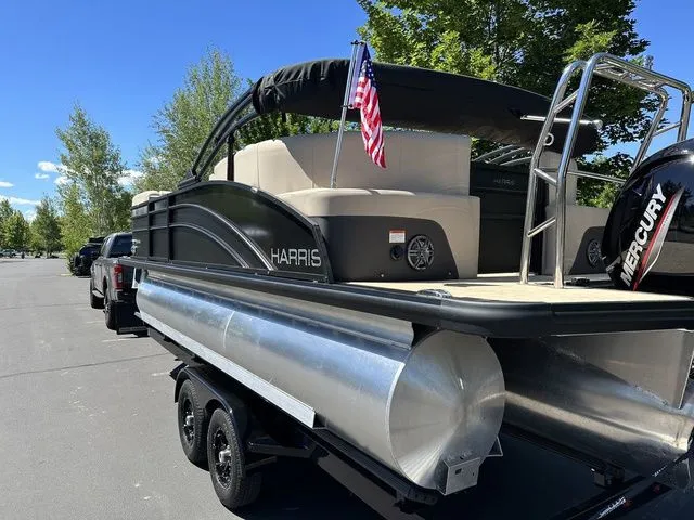 Slide: The Image of 2025 Harris Cruiser 210 CWDH pontoon boat on trailer, American flag, sunny day. - 13