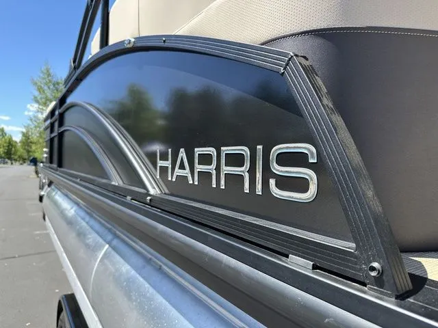 Slide: The Image of 2025 Harris Cruiser 210 CWDH pontoon boat, close-up of logo and sleek design. - 14