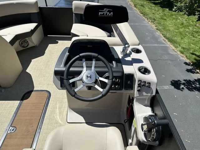 Slide: The Image of 2025 Harris Cruiser 210 CWDH boat interior with steering wheel and seating. - 26