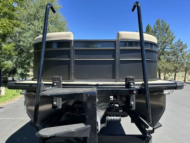 Slide: The Image of 2025 Harris Cruiser 210 CWDH pontoon boat on trailer, parked outdoors. - 3