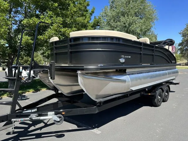 Slide: The Image of 2025 Harris Cruiser 210 CWDH pontoon boat on trailer, parked outdoors. - 4