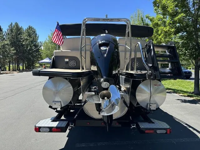 Slide: The Image of 2025 Harris Cruiser 210 CWDH pontoon boat with American flag, parked outdoors. - 6