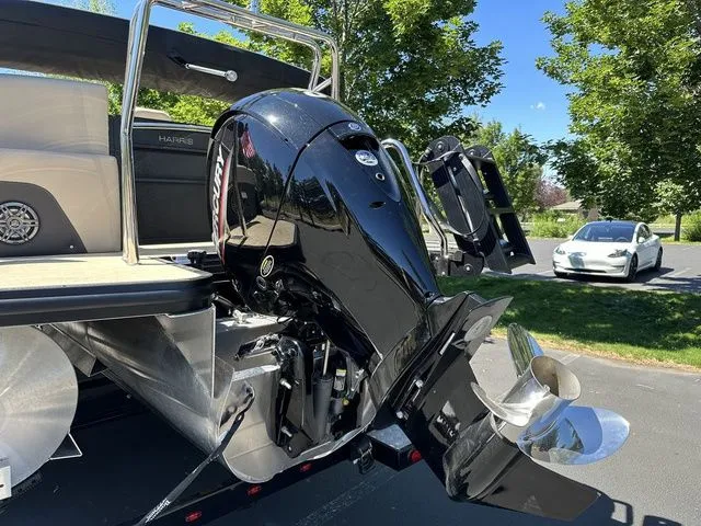 Slide: The Image of 2025 Harris Cruiser 210 CWDH boat with powerful outboard motor, parked outdoors. - 7