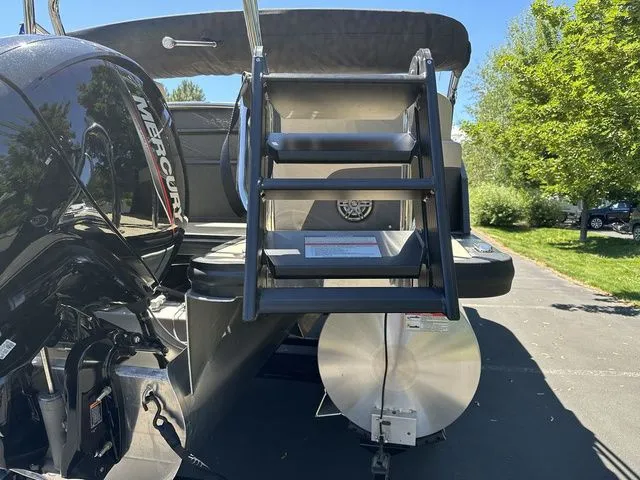 Slide: The Image of 2025 Harris Cruiser 210 CWDH boat with Mercury engine and rear ladder in sunny setting. - 8