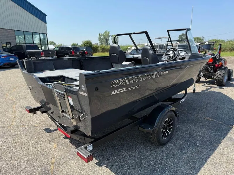 Slide: The Image of 2026 Crestliner 1750 Fish Hawk WT JS boat on trailer, parked outdoors. - 4