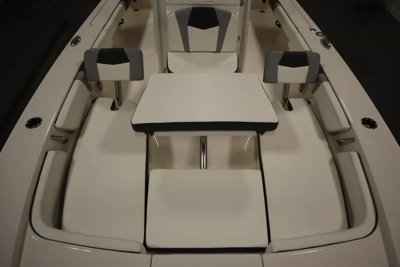 Slide: The Image of 2022 Robalo 246 Cayman boat interior with cushioned seating and table setup. - 21