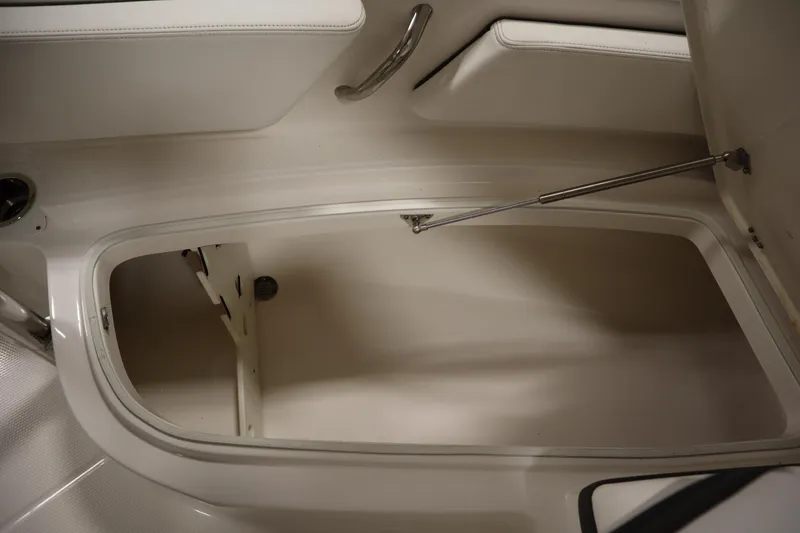 Slide: The Image of 2022 Robalo 246 Cayman storage compartment with open hatch and hydraulic support. - 22
